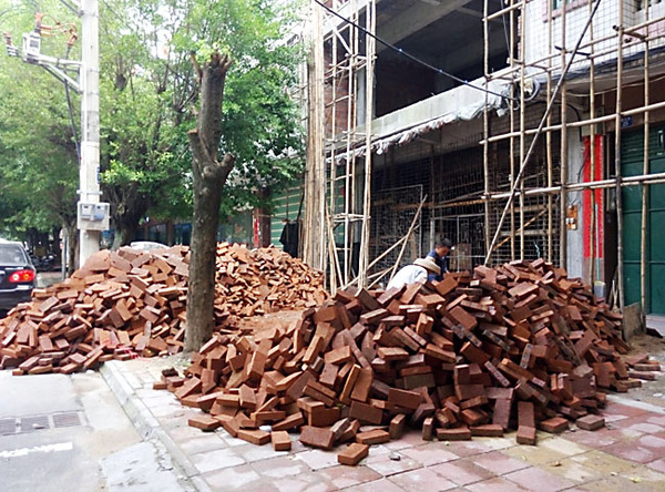 建設路建筑材料亂堆放，人行道變“攔路虎”